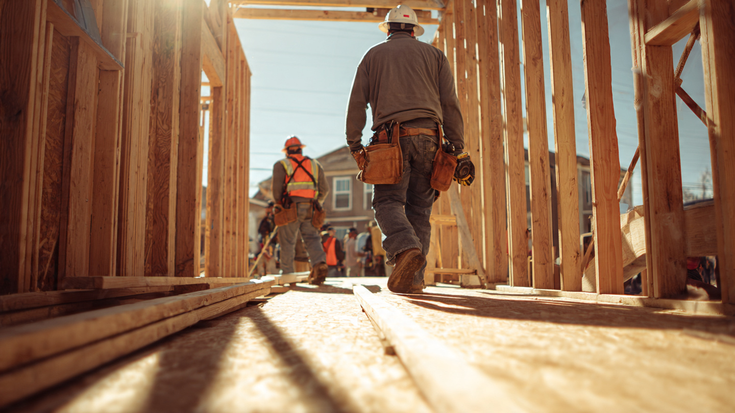 Construction workers on residential framing site with wearable safety sensors